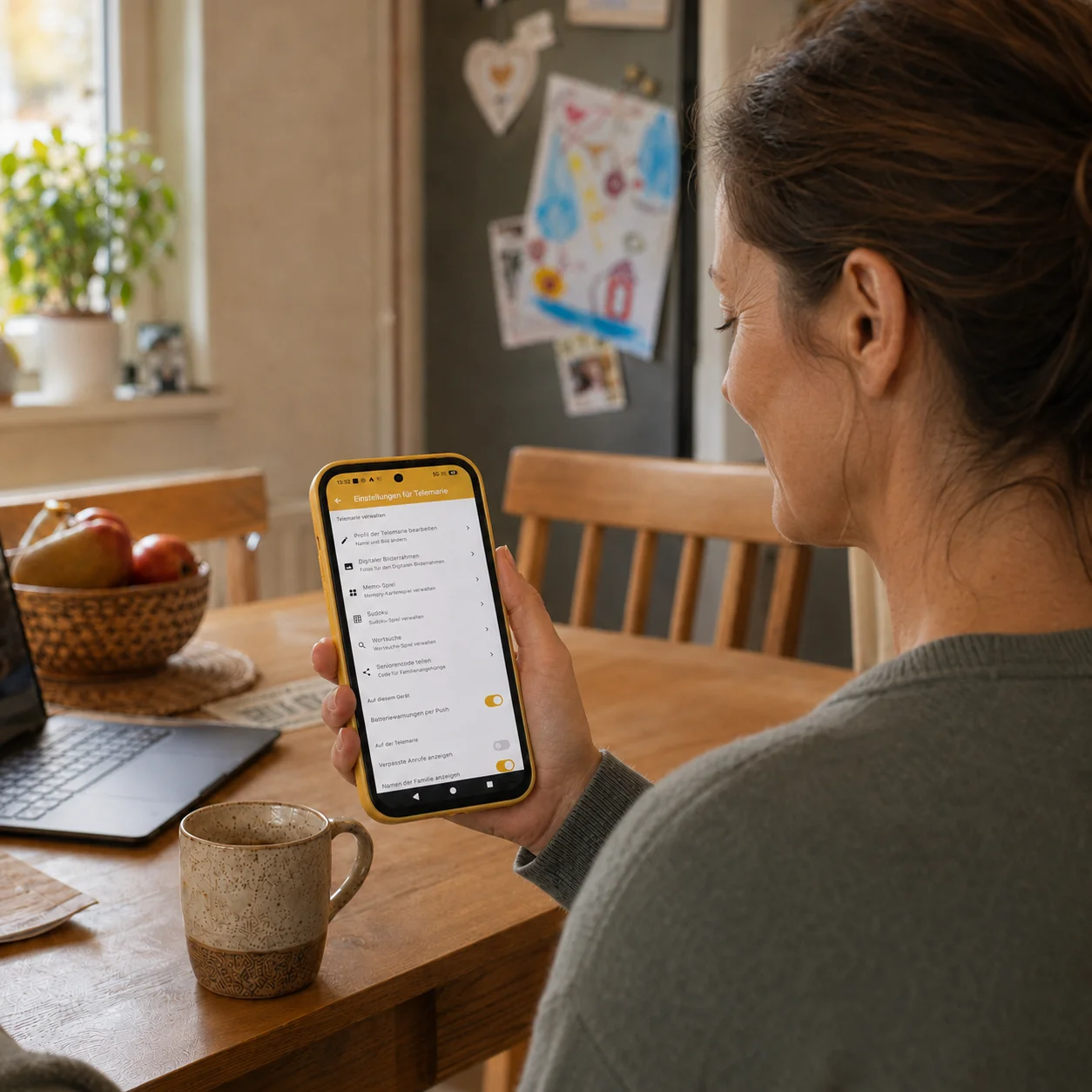 Angehörige schaut auf dem Smartphone in die Familien-App von Telemarie, um Einstellungen aus der Ferne zu verwalten.